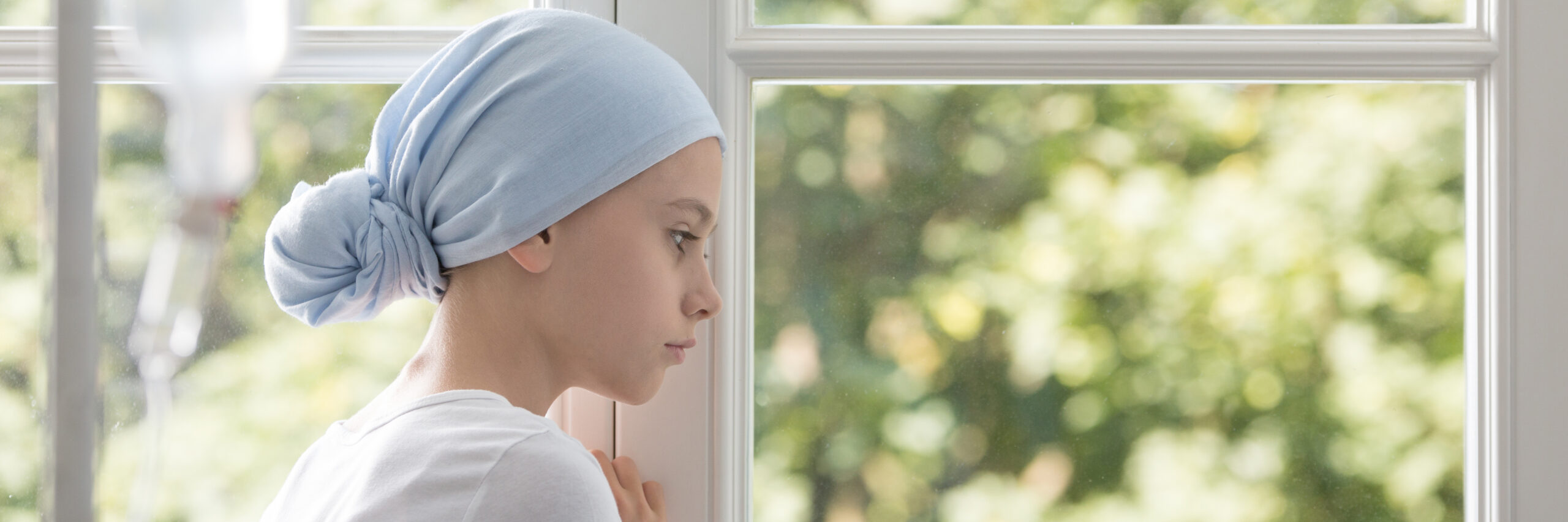 Panorama of sick girl with cancer wearing blue headscarf during treatment